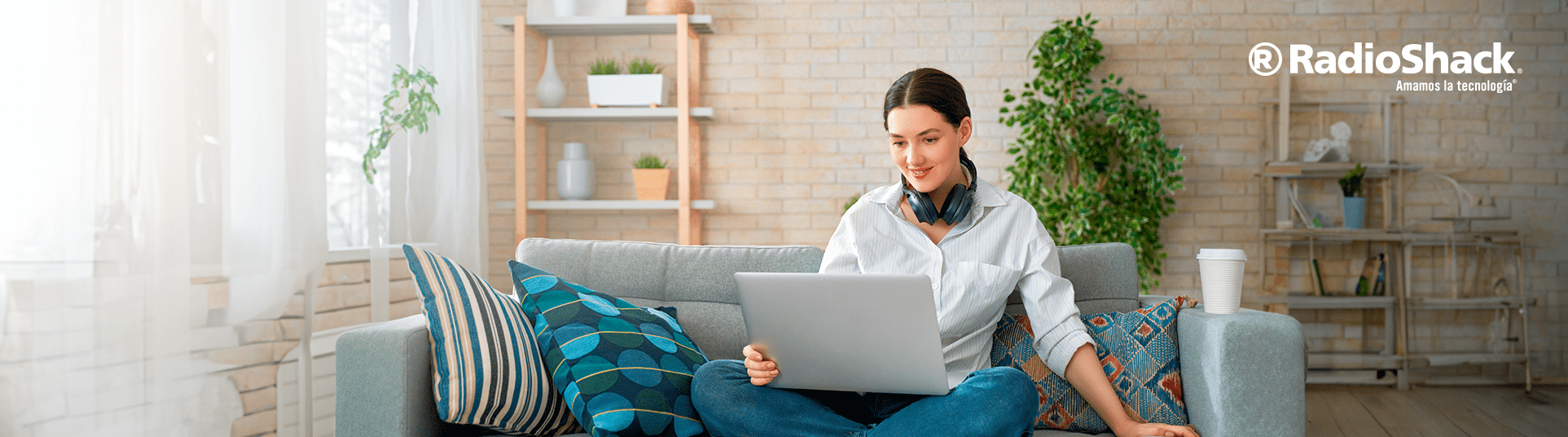 Una mujer esta usando su equipo de computo gris. Esta trabajando en su laptop haciendo home office.