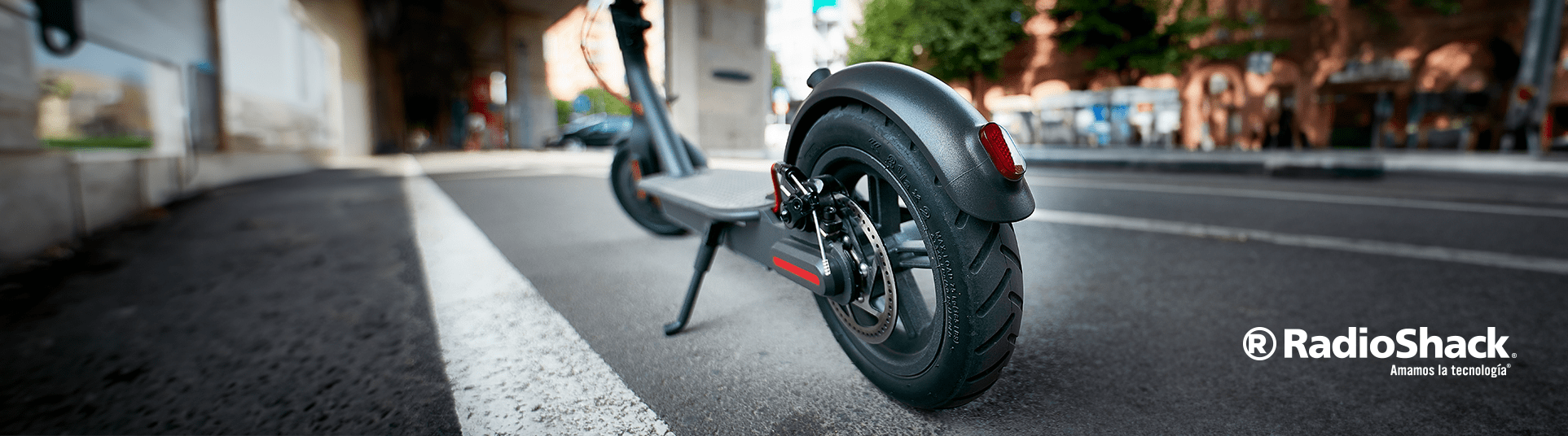 scooter electrico estacionado sobre la calle de una gran ciudad. El dueño queria comprar una bicicleta electrica, pero termino comprando un patin.
