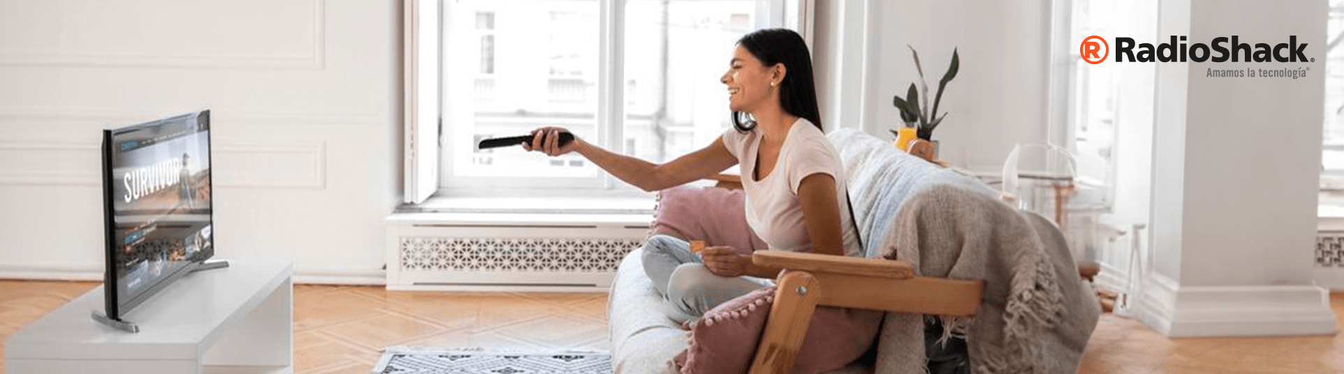 es vital que una smart tv tenga funciones de streaming, una mujer está viendo su televisor inteligente descansando un sabado en la sala de su hogar