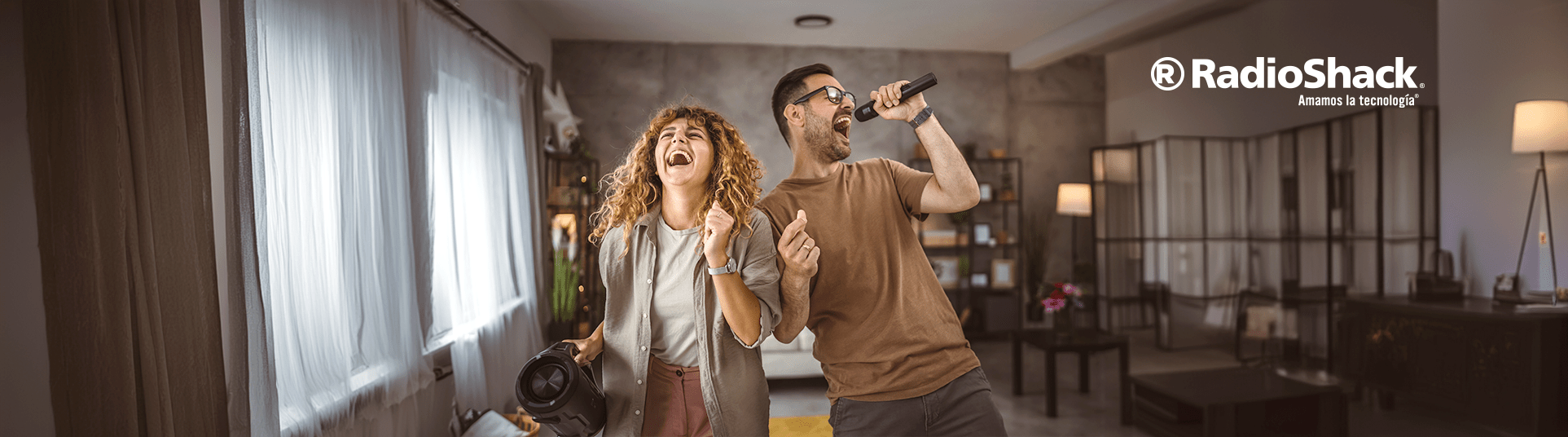 una pareja de jovenes que al parecer viven juntos estan festejando mientras cantan con un microfono y una bocina potente