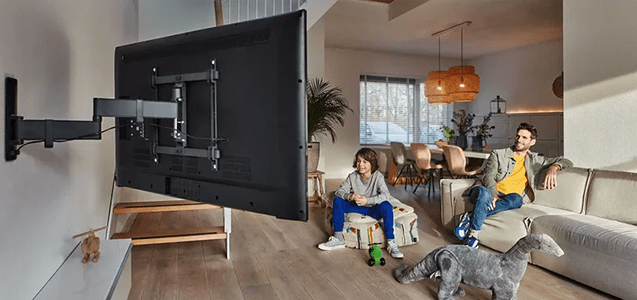 un padre de familia y su hijo aprovechan su nuevo soporte para pantalla al máximo en su sala de estar mientras miran la tv