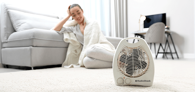una mujer recargada sobre el sofa de su sala se encuentra cómoda con su nuevo calefactor marca radioshack para esta temporada de frios